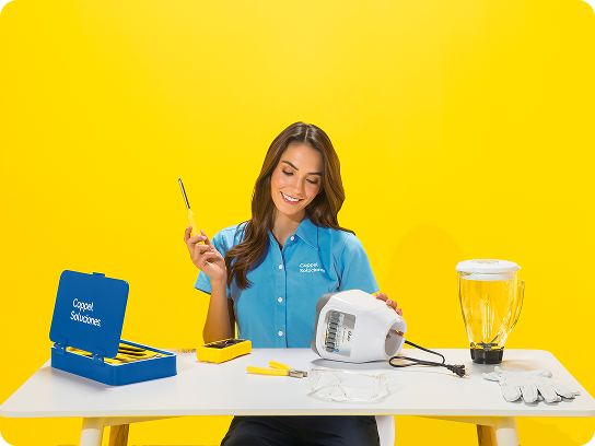 Una sololucionadora examina una licuadora sobre una mesa contra un fondo amarillo brillante.