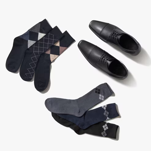 Composición de seis pares de calcetines de distintos diseños y un par de zapatos negros formales. Pulsa aquí para checar ropa interior Wallstreet, abre en pestaña nueva.