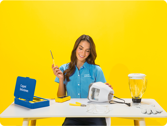 Un solucionadora armando una licuadora sobre una mesa contra un fondo amarillo brillante.